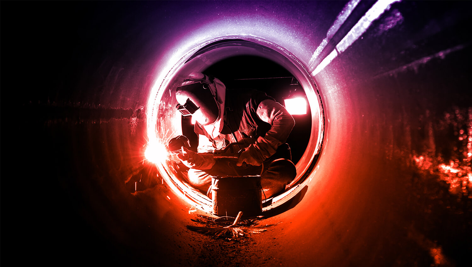 welder inside a pipe pipefitting marine engineering